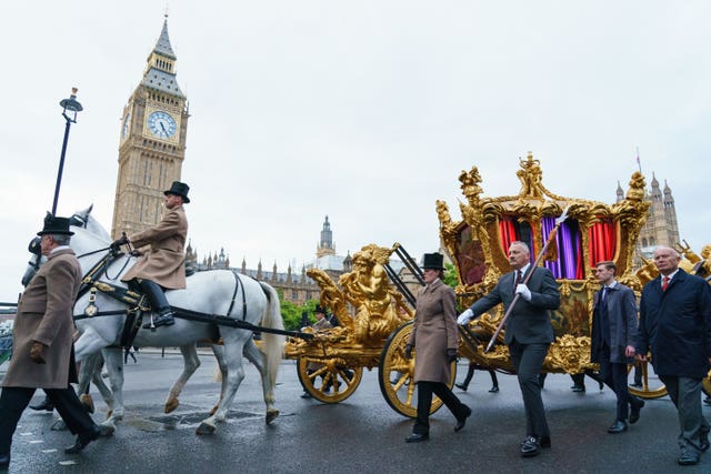 The gold state coach passes the Houses of Parliament during an early morning rehearsal as service personnel from the Royal Navy, British Army, and Royal Air Force conduct a final early morning rehearsal through London ahead of Sunday’s Platinum Jubilee Pageant, which will mark the finale of the Platinum Jubilee Weekend