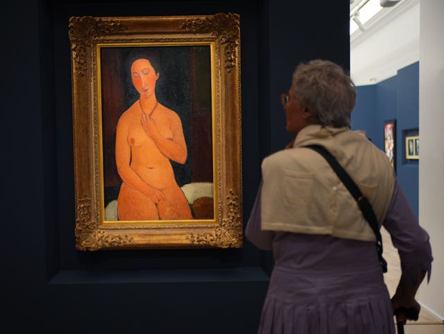 A woman looks at an artwork by Amedeo Modigliani