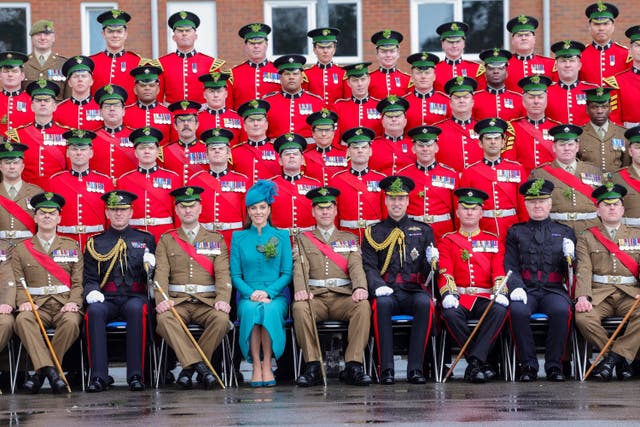 The Prince and Princess of Wales sit for a group photo during a visit to the 1st Battalion Irish Guards for the St Patrick’s Day Parade, at Mons Barracks in Aldershot