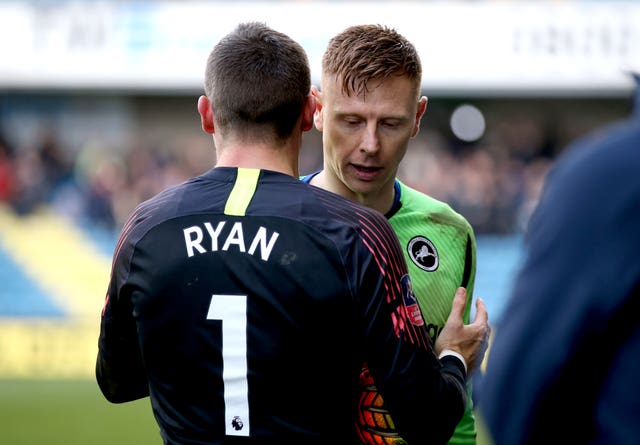 Brighton's Mat Ryan consoled fellow goalkeeper Martin after Millwall's elimination.