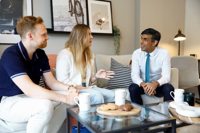 Prime Minister Rishi Sunak speaks to new homeowners Victoria and Ryan Adair during a visit to Hayes Village, a new housing development under construction by Barratt Homes in Hayes, west London