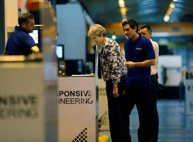 Theresa May on a tour of the Reece Group's Armstrong Works (Russell Cheyne/PA)