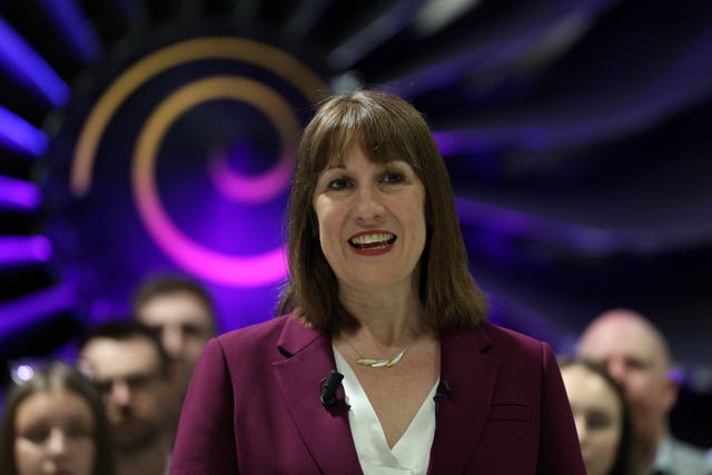 Chancellor Rachel Reeves giving a speech in front of a large jet engine