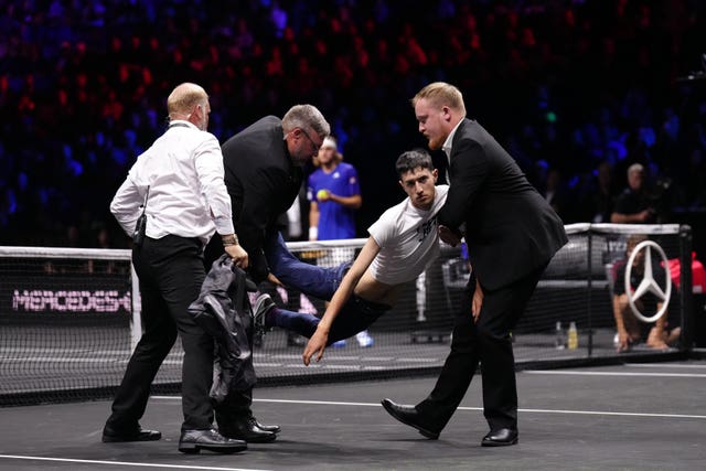 Stewards remove a protester after setting fire to the court