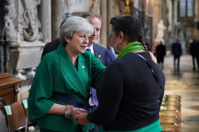 Theresa May and volunteer Claire Walker speak before the Grenfell Tower fire memorial service at Westminster Abbey in London to commemorate the victims of the Grenfell Tower fire.