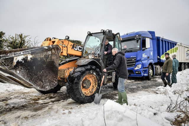 A JCB machine tries to tow a lorry stuck in snow near Marlborough, WIltshire (Ben Birchall/PA)
