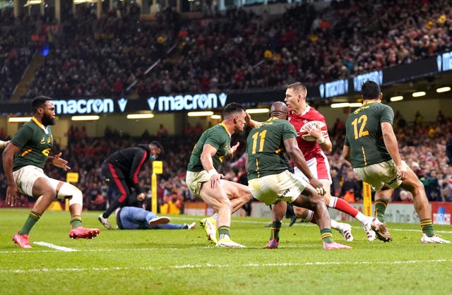 Liam Williams is tackled after jumping over a pitch invader