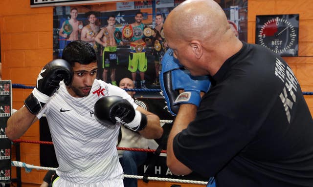 Khan's trainer Virgil Hunter (right) has urged him not to retire from boxing
