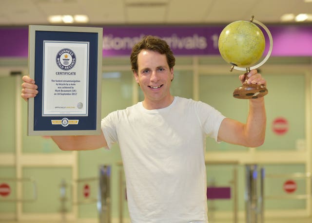 Handout photo of Cyclist Mark Beaumont, the fastest man to cycle around the globe, arriving at Edinburgh Airport from Paris with his Guinness Book of World Records certificates.