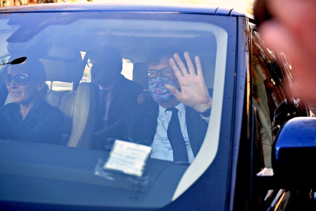 Crispin Odey, pictured in 2021, in a car holding his hand up to cover his face as members of the media try to take pictures of him