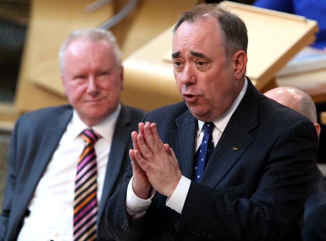 Alex Salmond speaking in Holyrood as Alex Neil looks on