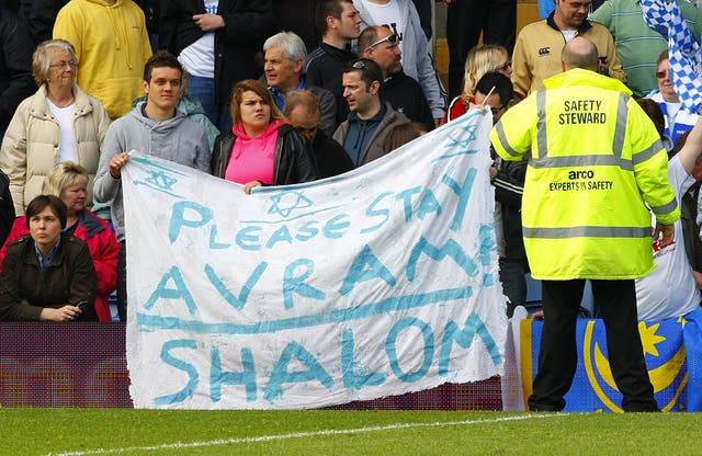 Portsmouth fans hold up a sign which asks manager Avram Grant to stay at the club 