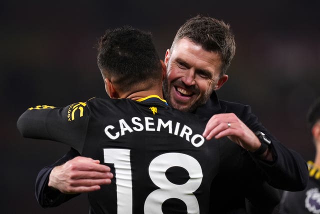 Michael Carrick embraces Casemiro after the win at Arsenal