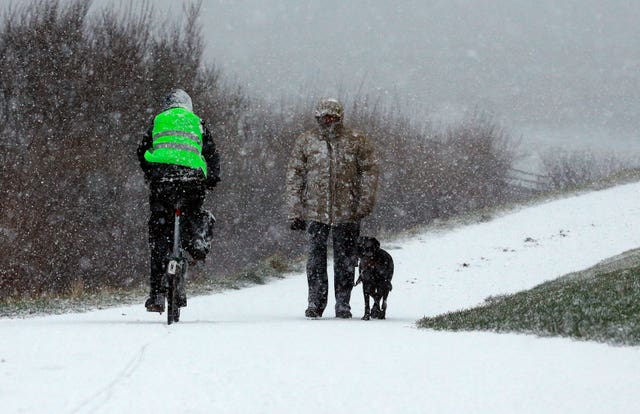 Cyclist and dog walker in the snow