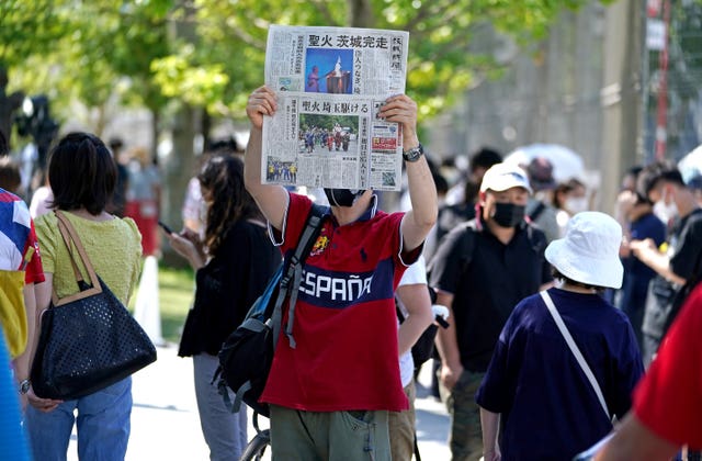 A newspaper is held up in protest outside the Olympic Stadium