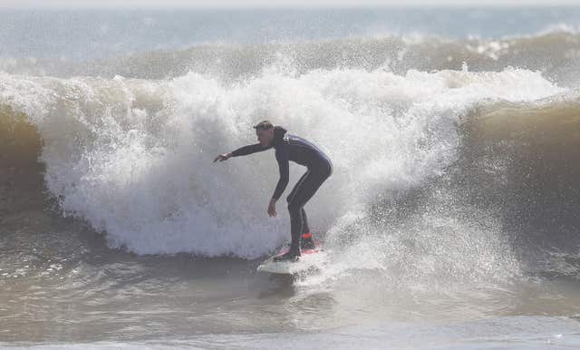 Surfers took advantage of the conditions to catch some waves (Andrew Matthews/PA) 