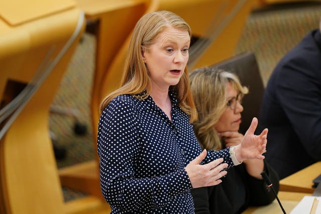 Shirley-Anne Somerville standing while speaking in Parliament