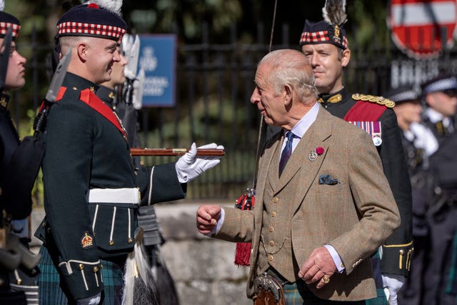 The King chatting to a soldier, who is smiling back at him