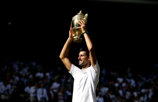 Novak Djokovic holds the Wimbledon trophy aloft for the fourth time