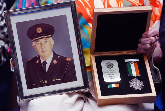 Bernadette O’Dea holds a photograph of her late husband Assistant Commissioner Edward O’Dea along with his bronze Scott Medal