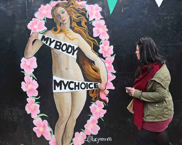 A woman passes a pro-choice mural in Dublin urging a yes vote (Niall Carson/PA)