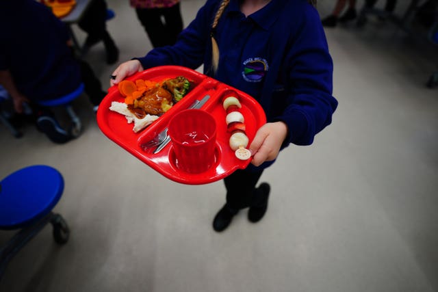 A child carries a school dinner tray