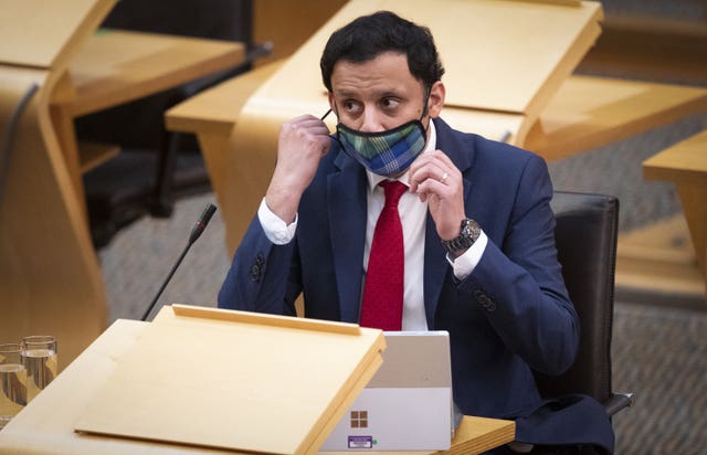 Anas Sarwar removing his mask in Holyrood
