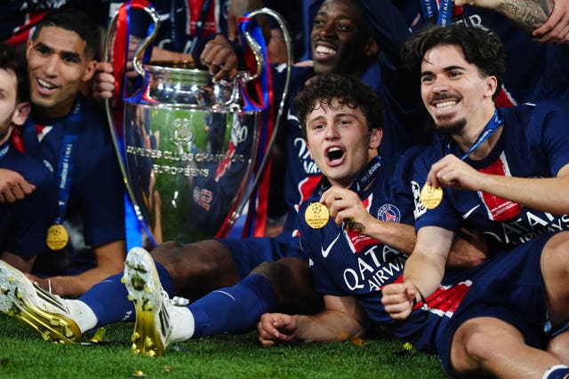 Paris St Germain’s Joao Neves and Vitinha celebrate with the Champions League trophy