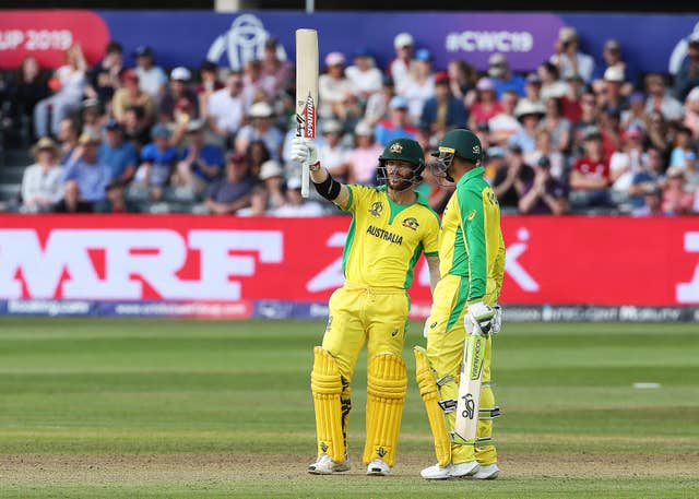 Australia’s David Warner raises his bat after reaching his half century 