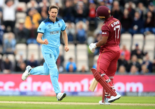 Chris Woakes celebrates taking England's first wicket of the day.