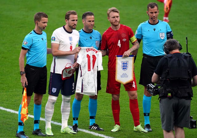 England captain Harry Kane and Denmark captain Simon Kjaer swap pennants and a signed Christian Eriksen shirt in tribute to the Denmark midfielder who suffered a cardiac arrest earlier in the tournament 