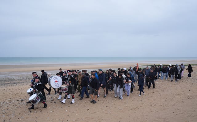 The Jedburgh Pipe Band lead walkers across Juno beach in Courseulles-sur-Mer at the end of a 22km walk along the French coastline taking in Sword, Juno and Gold beaches, in honour of the servicemen who landed there more than 80 years ago