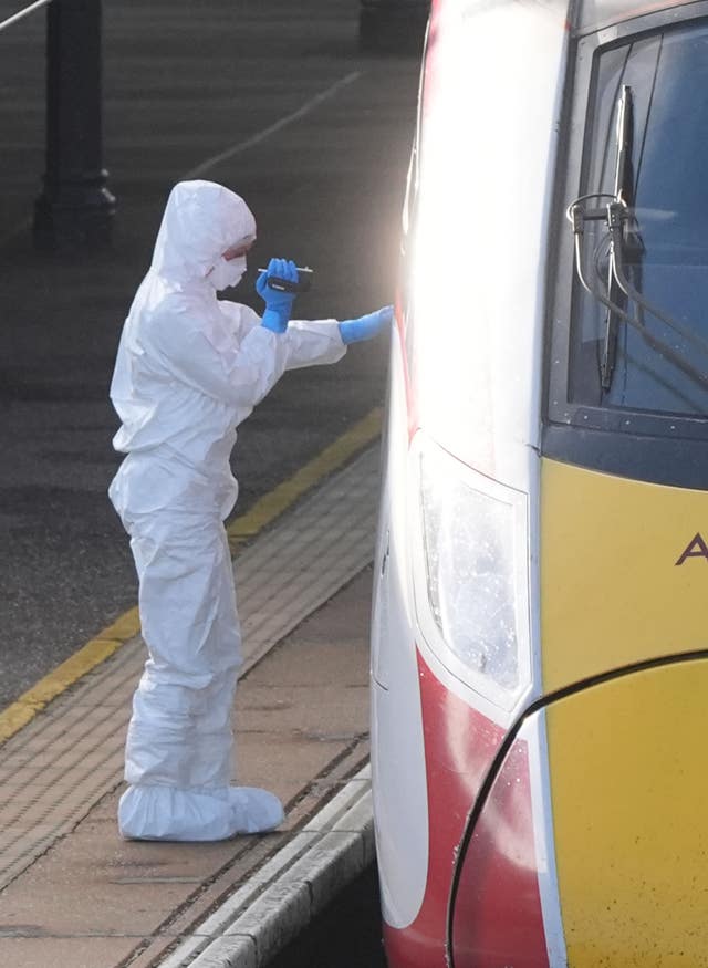 A forensic investigator on the platform by the train at Huntingdon station after the stabbing attack