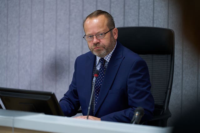 Lord Weir seated as chairman of the inquiry