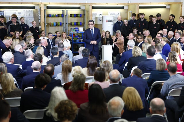 Andy Burnham surrounded by people as he delivers a speech to them