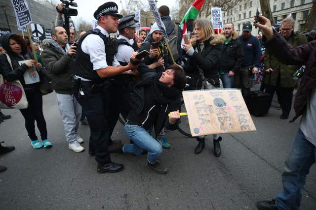 A person is held by police officers during a protest by Stop the War Coalition in Whitehall (Yui Mok/PA)