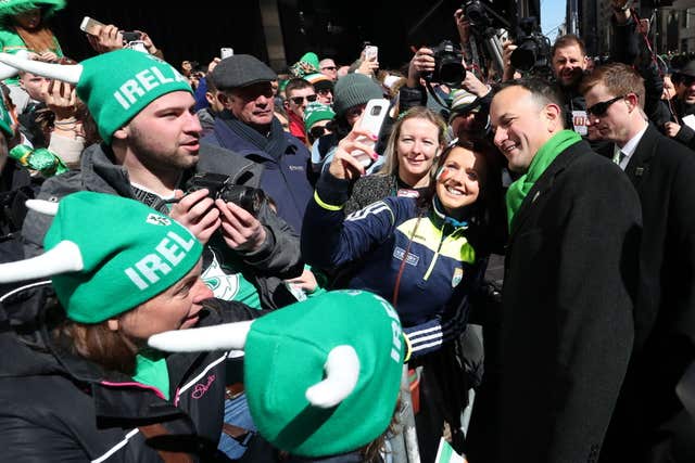 The Taoiseach poses for selfies with people watching the  parade (Niall Carson/PA)
