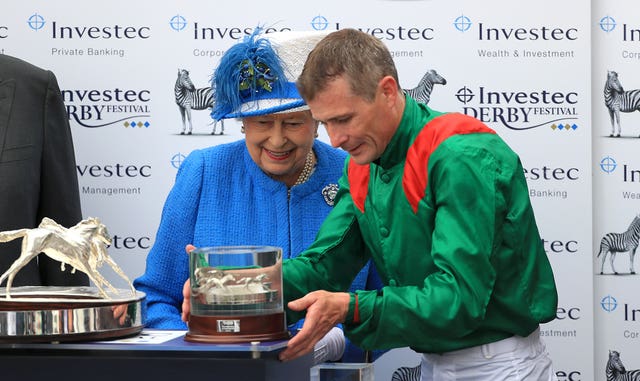 The Queen presents Pat Smullen with his Derby trophy following the victory of Harzand