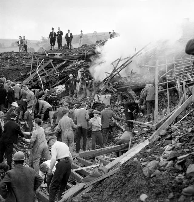 Rescue workers tear into the mud and rubble burying the ruins of seven houses which were engulfed by a moving mountain of coal slurry at Aberfan, near Merthyr Tydfil, in 1966 (PA Archive/PA)