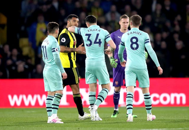 Troy Deeney, second left, speaks to Arsenal’s Granit Xhaka 