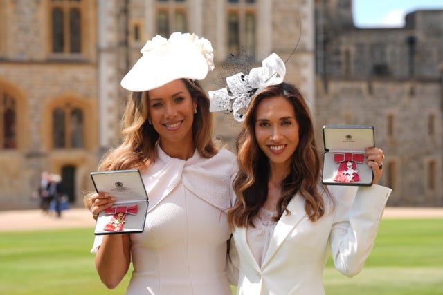 Leona Lewis and Myleene Klass in white outfits and hats holding medals