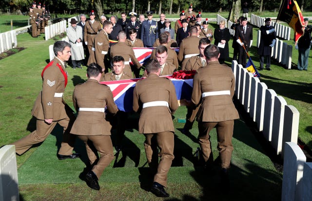 Soldiers prepare to bury two coffins during a burial service at the Commonwealth War Graves Commission’s Wytschaete Military Cemetery, near Ypres