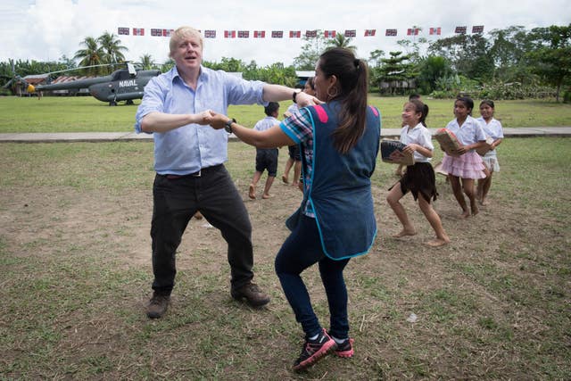 Boris Johnson dancing with infant class teacher Adriana Pinedo at the village school in Santa Marta, on the bank of the Amazon (Stefan Rousseau/PA)