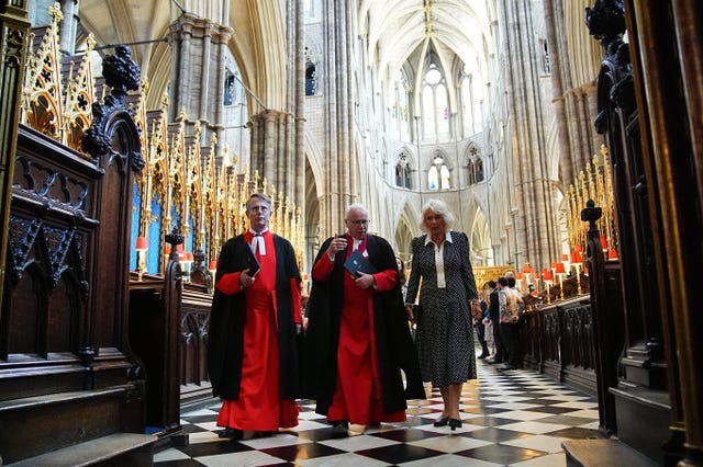 Camilla with the Dean of Westminster, the Very Reverend Dr David Hoyle (centre) walking through Westminster Abbey