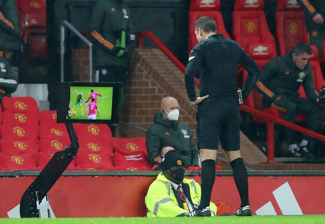 Referee David Coote consults the VAR before disallowing a penalty for West Brom