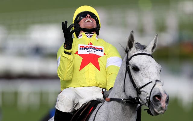 Harry Skelton celebrates winning the Champion Chase with Politologue