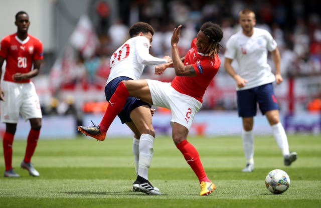Alli and Switzerland’s Kevin Mbabu battle for the ball 