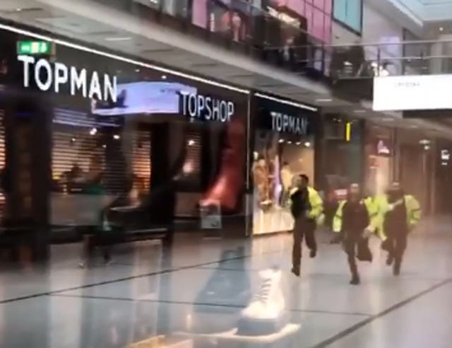 Police running through the Arndale Centre