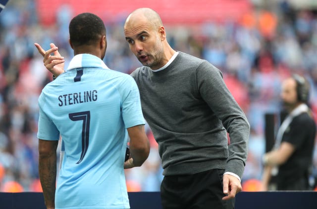 Manchester City's Raheem Sterling (left) and manager Pep Guardiola (right) during the FA Cup Final.