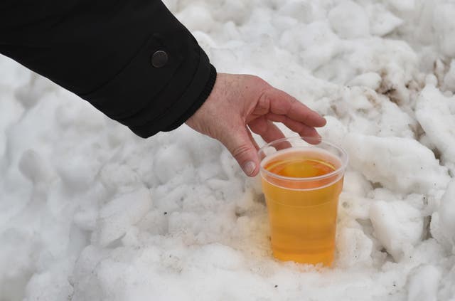 A Bristol City fan makes use of the snow to keep his pint of beer cold before the game (Empics/PA)